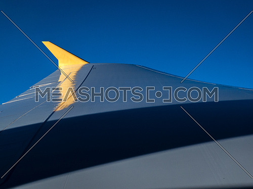 Plane wing during flight with blue skyes