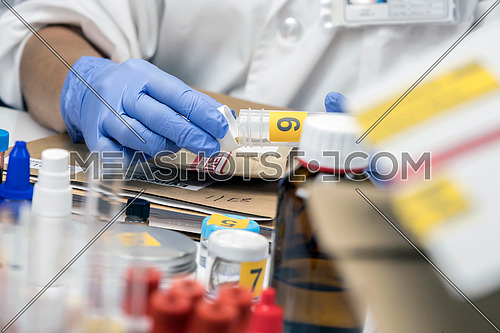 Scientific Police hold evidence of a crime in scientific lab, conceptual image