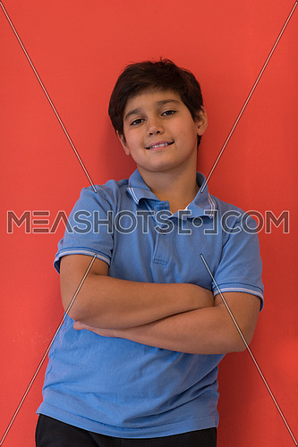 Portrait of a happy young boy in front of colored background