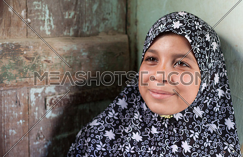 Young girl close to the house door in Fayoum street