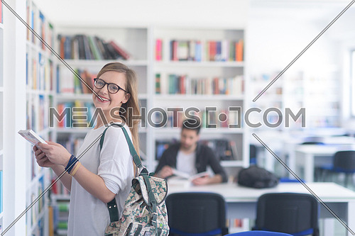 smart looking famale student girl  in collage school library selecting book to read