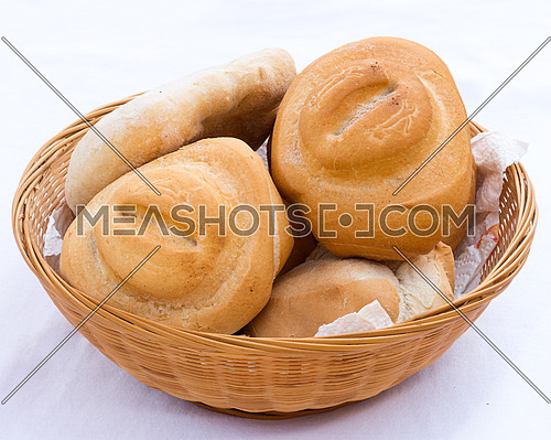 In the picture bread in wicker basket isolated on white.