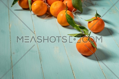 Fresh tangerines on blue wooden table. Copy space