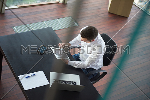 top view of happy young business man,  work tablet and laptop and relax at modern bright office interior, successful hipster with beard at workplace