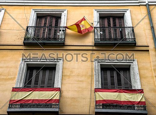 Typical building facade with flags in balconies in Madrid, Spain