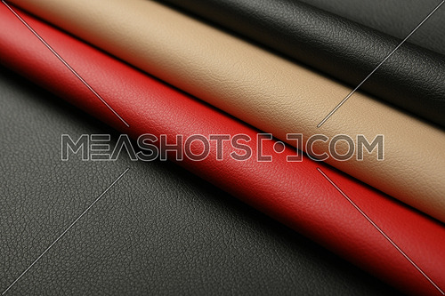 Close up background of black, red and beige white natural leather grain, high angle diagonal view