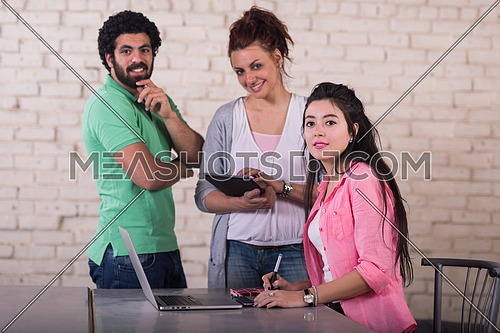 informal group of young middle eastern businessmen having a meeting while using a laptop in a modern office