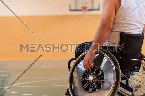 Close up photo of wheelchairs and handicapped war veterans playing basketball on the court. High quality photo