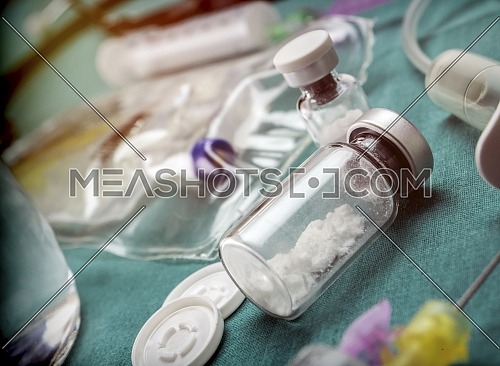 Vial with medicine in dust without diluting in a table of operating room of a hospital, conceptual image