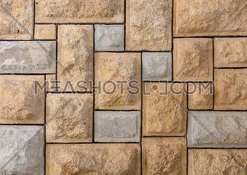 Background of pattern of yellow and gray decorative uneven stone wall surface