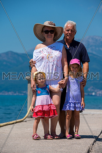 portrait of  happy grandparents with cute little granddaughters standing by the sea during Summer vacation  Healthy family holiday concept
