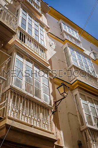 Cadiz Spain- March 31: Detail of balconies and large windows on the time of the nineteenth century, Narrow street with traditional architecture in Cadiz, Andalusia, southern Spain