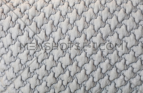 Close up background texture of neutral gray soft tufted textile upholstery pattern