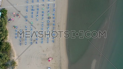 Aerial shot of sandy beach with umbrellas, typical adriatic shore.Summer vacation concept.Lido Adriano town,Adriatic coast, Emilia Romagna,Italy.