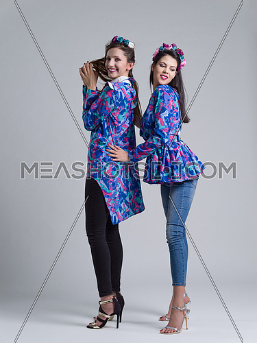 two Fashion Model girls isolated over white background. Beauty stylish women posing in fashionable clothes  Casual style with beauty accessories. High fashion urban style