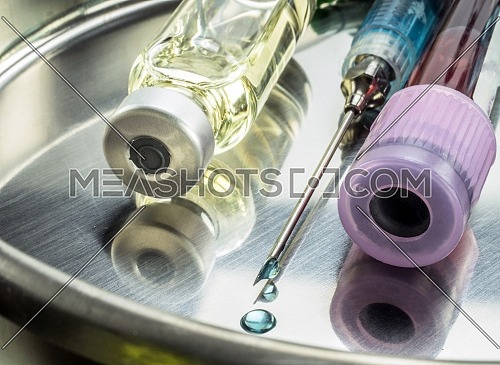 Jeringa con gota de medicamento en la aguja, imagen conceptual