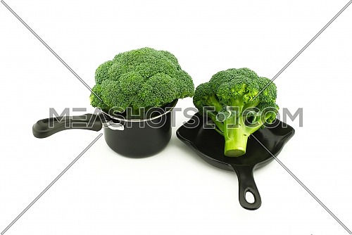 Fresh broccoli in a pot and pan on a white background. Fried or boiled concept