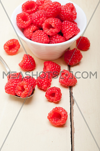 bunch of fresh raspberry on a bowl and white wood rustic  table