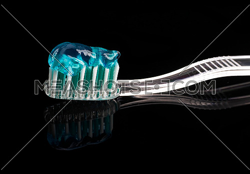 tooth brush and paste over black reflective background