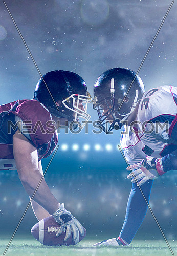 american football players are ready to start a match on modern field at night