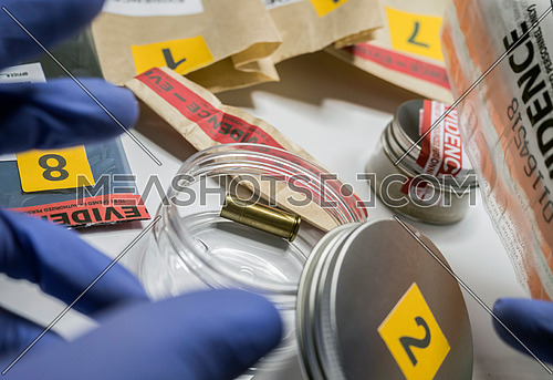 Evidence of crime scene, bullet cap in laboratory scientist, conceptual image, horizontal composition