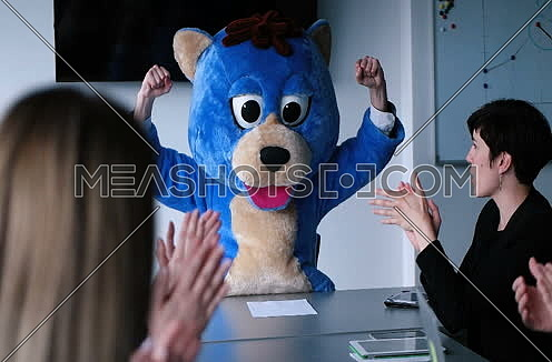 boss dressed as bear having fun with business people in trendy office