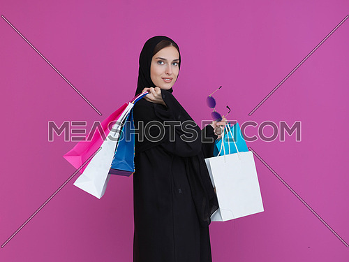 Happy muslim girl posing with shopping bags. Arabic woman wearing traditional black clothes and sunglasses representing rich and  luxurious lifestyle