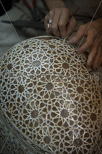 Decorating the back of an Oud with Islamic designs made of Shell