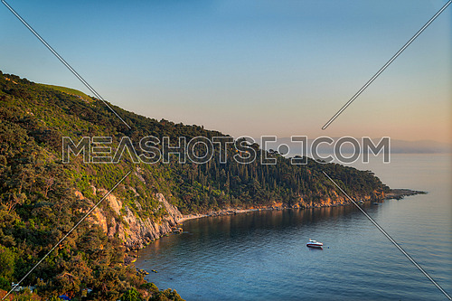 View from the top of mountains of Buyukada island, one of the Princess Islands (Adalar), Marmara Sea, Istanbul, Turkey, with green woods, calm sea, and clear sky at sunset time