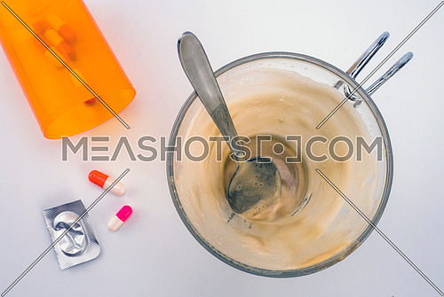 Medication during breakfast, capsules next to a glass of coffee, conceptual image, horizontal composition