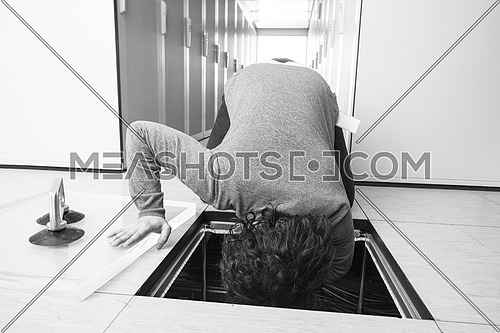 young IT engineer connecting cables in server room at modern data center