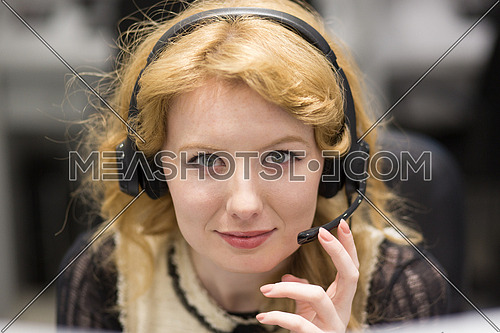 young smiling female call centre operator doing her job with a headset