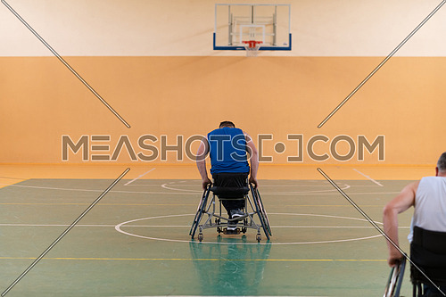 photo of wheelchairs and handicapped war veterans playing basketball on the court. High quality photo