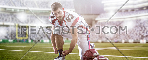 American Football Player preparing for match on big modern stadium field with lights and flares