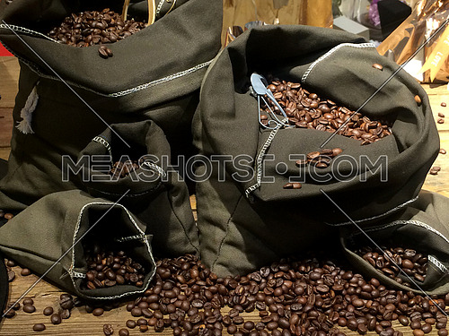 coffee beans on bags over rustic wood background