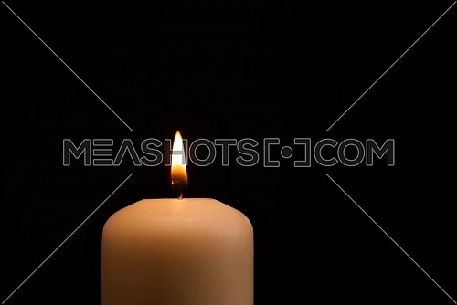 Candle burning in the darkness. Conceptual image with copy space