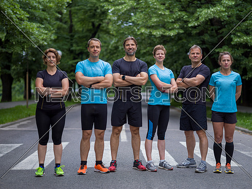 portrait of a group healthy people jogging in city park, runners team on morning training