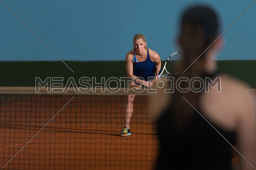 Portrait Of Two Beautiful Women Playing Tennis Indoor - Isolated On Black