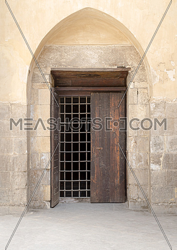 Recessed wooden window with decorated iron grid over stone bricks wall, Medieval Cairo, Egypt