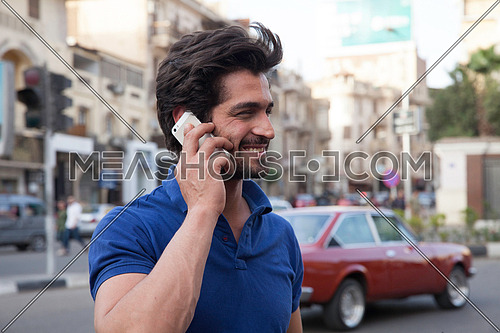 A young man in the street talking on his mobile