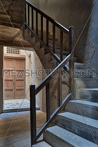 Ascending staircase with wooden balustrade and wooden closed ornate door at the background, Prince Taz palace, old Cairo, Egypt