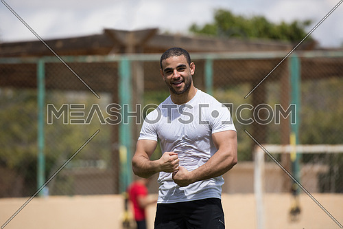Portrait of a young middle eastern Athletic-built man in the external field of fitness which is preparing for exercise