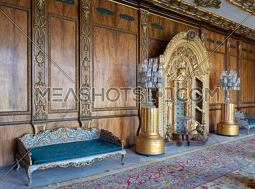 Manial Palace of Prince Mohammed Ali Tawfik. Residence of prince's mother with golden ornate niche, blue couch and ornate wooden wall, Cairo, Egypt