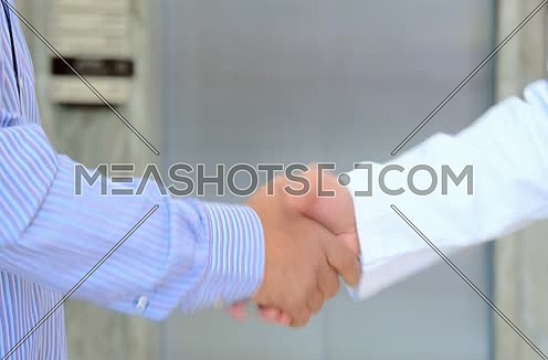 close up of doctor and patient shaking hands