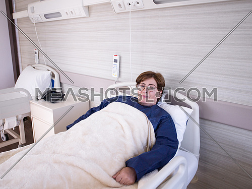 older woman as  patient  lies in hospital bed