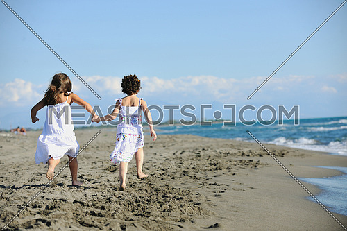 happy two little girls have fun and joy time at beautiful beach while running from joy 