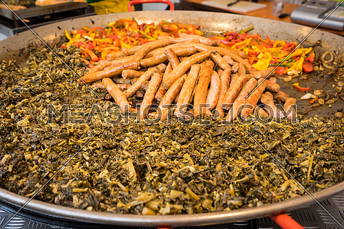 Typical food of Puglia with sausage, turnip top and peppers, prepared in a large pot during a food fair