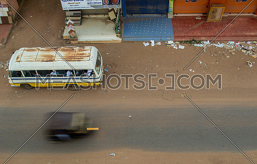 a top shot showing a bus and a tok tok speeding in an empty street in Sudan
