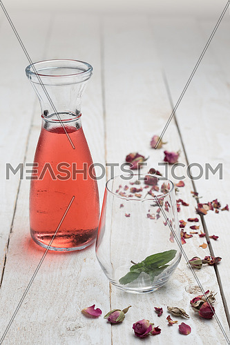 Glass of red solution and an empty glass on a wooden background