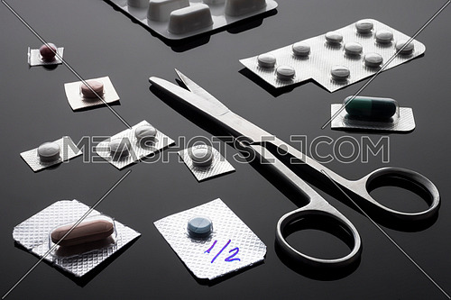 Monodose medication pills with scissors, conceptual image, horizontal composition